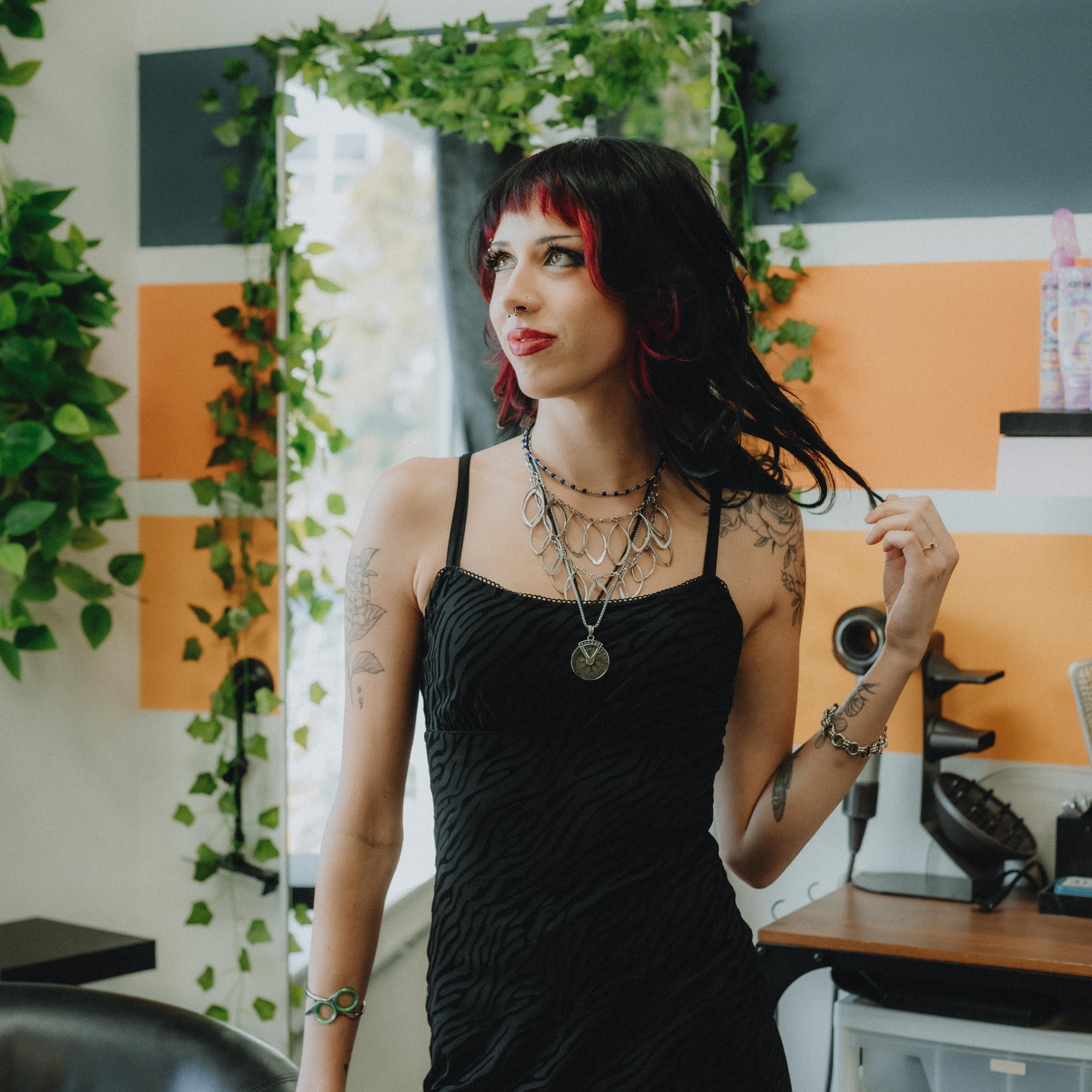 Rachel, stylist at Keenan Salon, smiling and wearing a green top with a patterned jacket, specializing in vivid haircolor, creative cuts, and confidence-boosting styles in Atlanta.